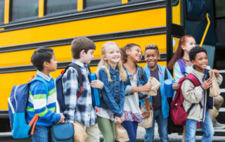 SchoolDoc - Student Health Record Management Software - Kids in front of a School Bus